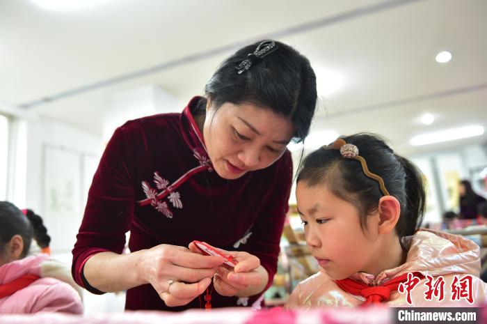 江西省級非遺豫章繡傳(chuan) 承人手把手指導小學生繡製2022年北京冬奧會(hui) 吉祥物“冰墩墩”形象。　喻雲(yun) 亮 攝