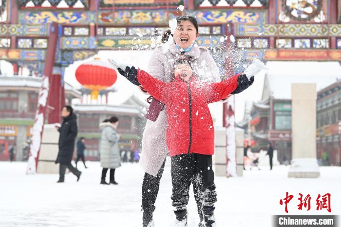 2月13日，家長與(yu) 小朋友在呼和浩特市大召廣場享雪趣。　劉文華 攝