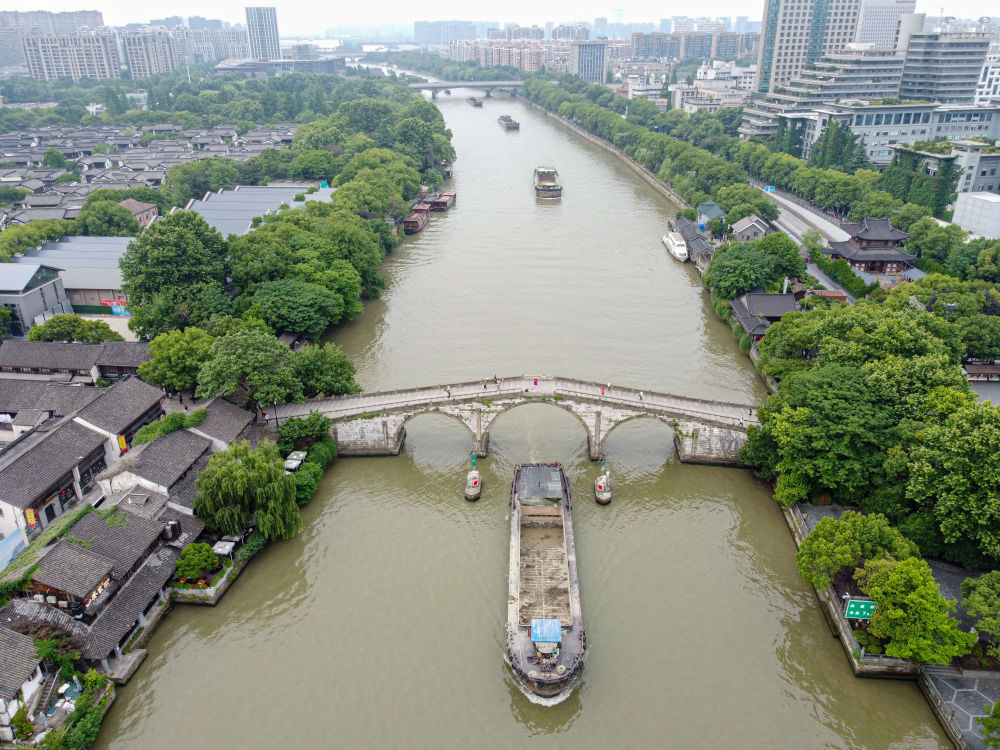 5月27日，一艘貨船駛過京杭大運河南端標誌建築杭州拱宸橋。(無人機照片)新華社記者江漢 攝