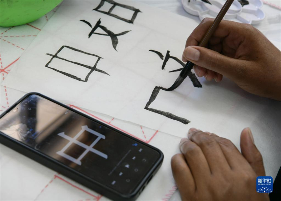 4月18日，肯尼亞(ya) 學生在內(nei) 羅畢大學孔子學院舉(ju) 辦的活動上寫(xie) 毛筆字。肯尼亞(ya) 內(nei) 羅畢大學孔子學院18日舉(ju) 辦“中文，增進文明對話”主題活動，慶祝即將到來的第14個(ge) 聯合國中文日。肯尼亞(ya) 學生參與(yu) 互動，進行書(shu) 法、剪紙、唱中文歌等活動。新華社記者 韓旭 攝