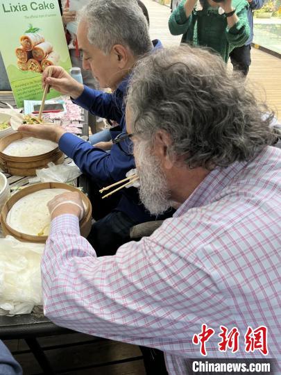 外交官們(men) 體(ti) 驗做立夏餅。　華東(dong) 師範大學供圖