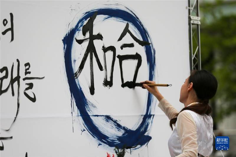 5月30日，在韓國首爾舉(ju) 辦的“中日韓合作之日”慶祝活動中，表演者進行中日韓精神——2023年度漢字“和合”書(shu) 法表演。新華社記者 王益亮 攝
