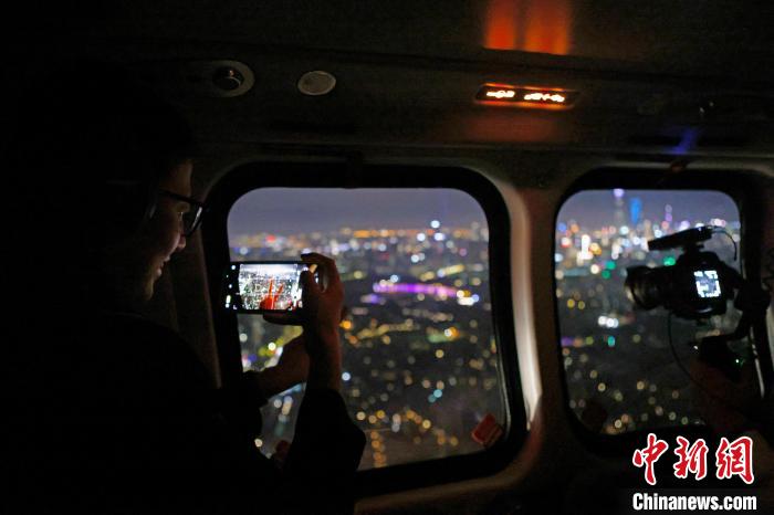 6月3日晚，遊客乘坐上海新空直升機有限公司直升機開啟鳥瞰黃浦江空中圓夢之旅，並用手機拍攝城市夜景。　殷立勤 攝