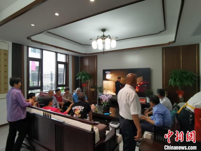 親(qin) 友們(men) 集中在費俊龍家中觀看返程的視頻。　鍾升 攝