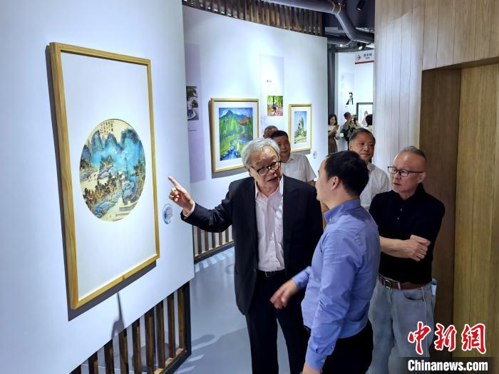 海峽兩(liang) 岸藝術家畫展上，藝術家進行藝術交流。　付敬懿 攝