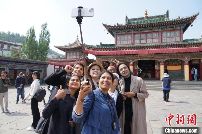 圖為(wei) 外國記者在塔爾寺合影。　馬銘言 攝