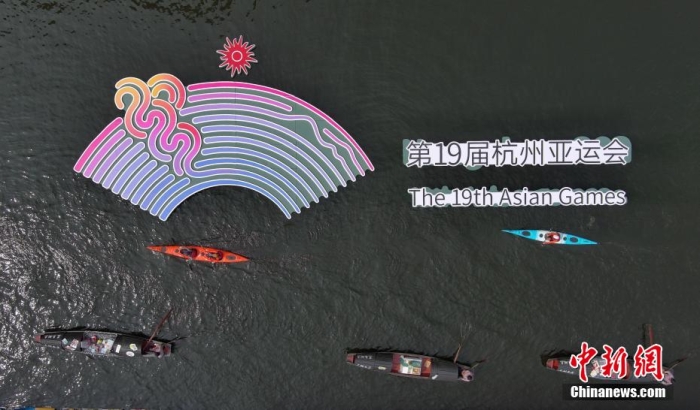 資料圖為(wei) 烏(wu) 篷船和皮劃艇從(cong) 杭州亞(ya) 運會(hui) 標識前劃過。王剛 攝