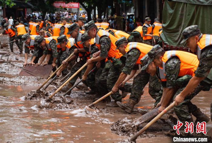 7月4日，萬(wan) 州區五橋街道，武警官兵清理街道上的淤泥。　冉孟軍(jun)  攝