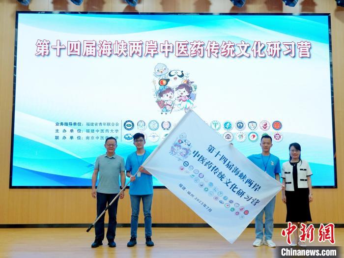 共青團福建省委副書(shu) 記吳雪(右一)、福建中醫藥大學黨(dang) 委副書(shu) 記林羽(左一)為(wei) 兩(liang) 岸學生代表頒授營旗。　許燁婷 攝