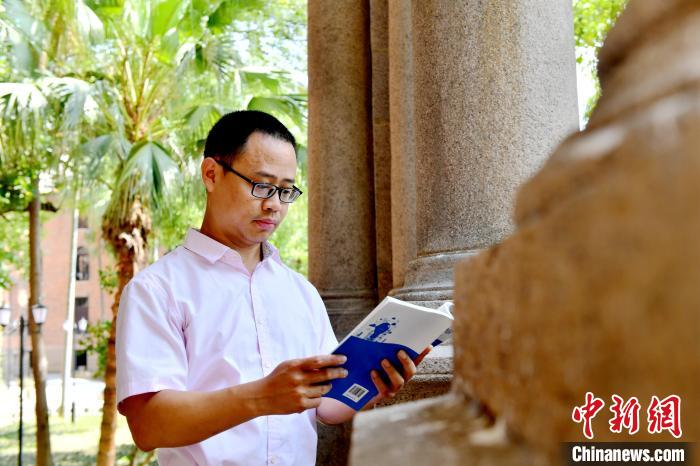 圖為(wei) 福建師範大學教育學院台灣教師陳昭誌正在看書(shu) 。　呂明 攝