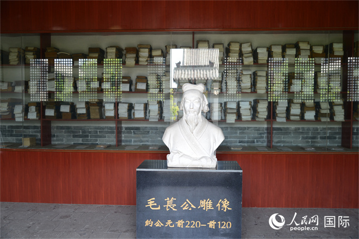 河間詩經齋毛萇雕像。雕像後書(shu) 櫥中陳列的是曆代各版本《詩經》及譯本。 人民網 趙昭攝