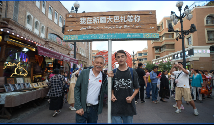 潘維廉和維吾爾族青年伊木蘭(lan) “打卡”大巴紮。主辦方供圖