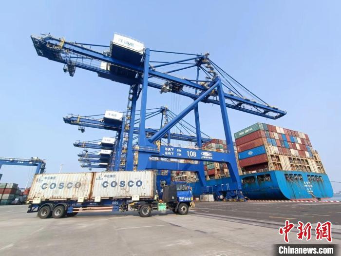 圖為(wei) 海南洋浦國際集裝箱碼頭，卡車將集裝箱從(cong) 後方堆場運往碼頭裝卸區。　張月和 攝