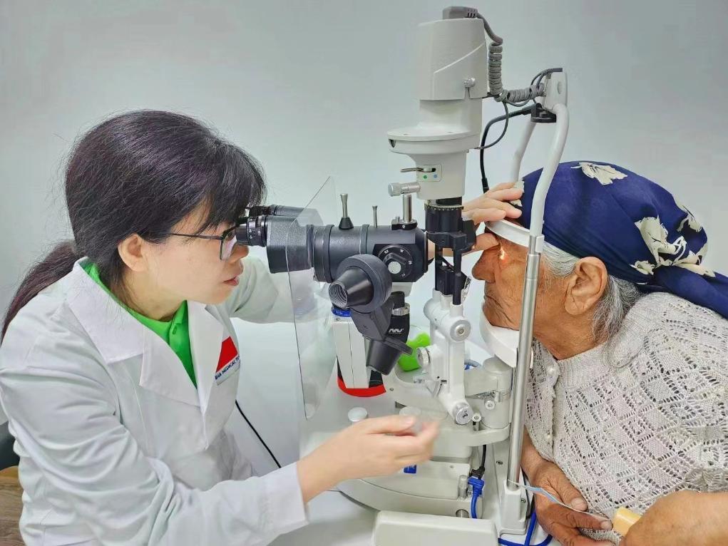 北京大學人民醫院眼科醫生鮑永珍正在為(wei) 中亞(ya) 白內(nei) 障患者進行眼部檢查。（北京大學人民醫院供圖）