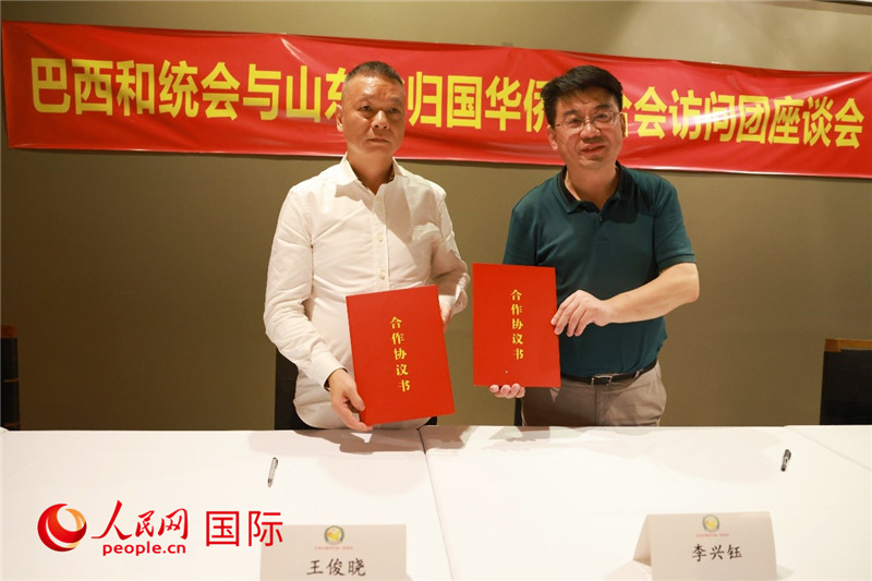 中國僑(qiao) 聯副主席、山東(dong) 省僑(qiao) 聯主席李興(xing) 鈺（右）與(yu) 巴西和統會(hui) 會(hui) 長王俊曉簽署合作協議書(shu) 。人民網記者 陳海琪攝