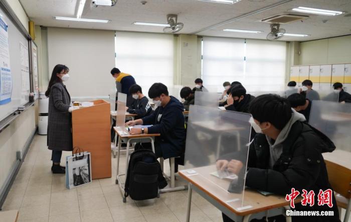 12月3日，延遲近一個(ge) 月的韓國高考舉(ju) 行。據韓國教育部消息，今年考生約49.34萬(wan) 人，創曆史最低紀錄。圖為(wei) 在首爾某考點內(nei) ，考桌上設有隔板。