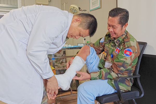 中國第22批赴黎維和醫療分隊軍(jun) 醫為(wei) 患者打石膏固定患肢。李清竹攝
