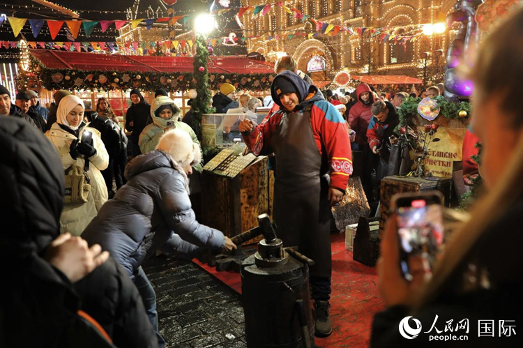 遊客在新年集市上體(ti) 驗製作紀念幣。人民網記者 隋鑫攝