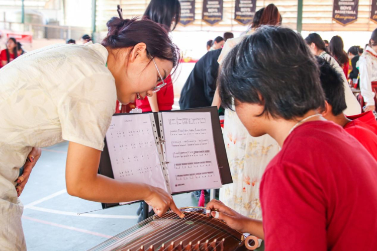 誌願者教師指導學生彈奏古箏。活動主辦方供圖