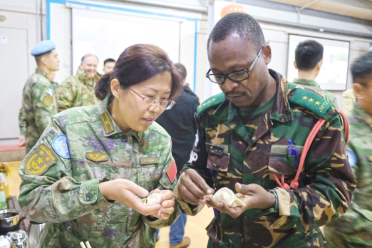 圖為(wei) 維和官兵與(yu) 外軍(jun) 人員共同包餃子。胡光明攝