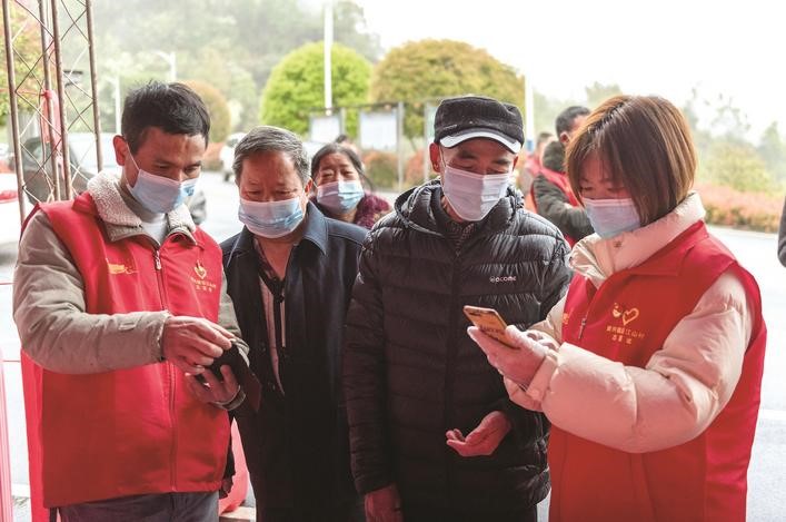 長沙縣黨(dang) 員誌願者正在幫助參與(yu) 核酸檢測的群眾(zhong) 掃描“場所碼”。劉思源 攝