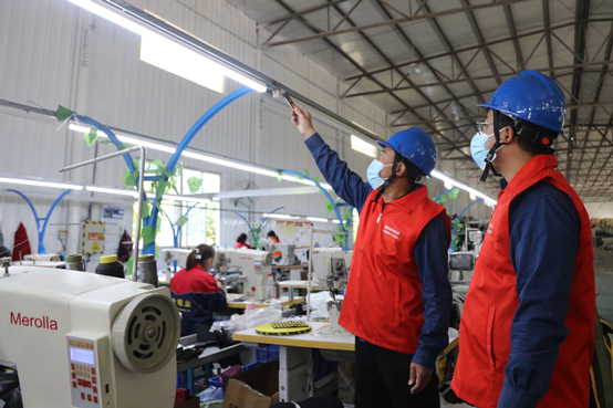國網廣平縣供電公司共產(chan) 黨(dang) 員服務隊到當地服裝加工企業(ye) 了解企業(ye) 用電需求，幫助企業(ye) 排查安全用電隱患。施振宇攝
