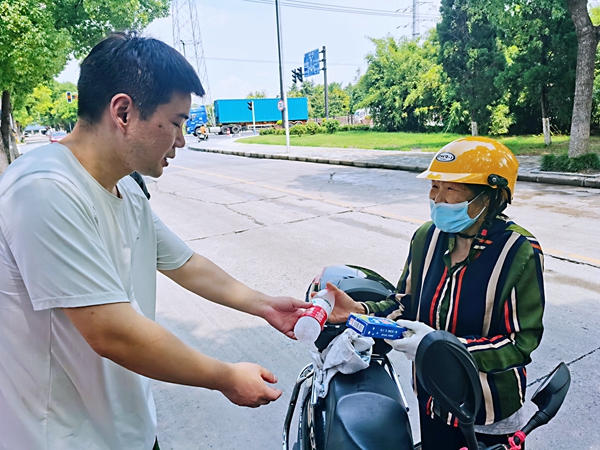 何超為(wei) 過路的老人送上礦泉水和冷飲。人民網記者 王繼亮攝