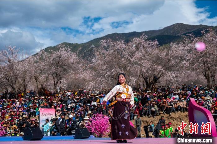 桃花林下精彩的“桃花仙子”選拔吸引村民或遊客。　劉忠俊 攝