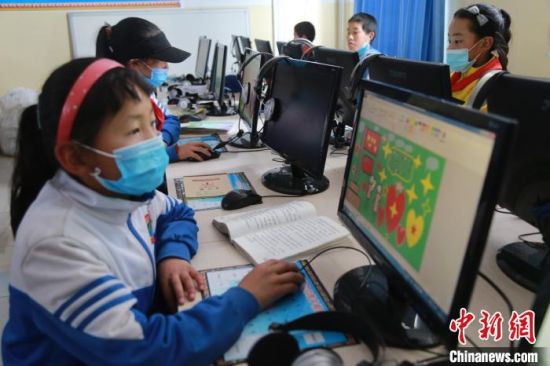 圖為(wei) 鄉(xiang) 村學校少年宮的孩子們(men) 正在上電腦課。　才讓本　攝