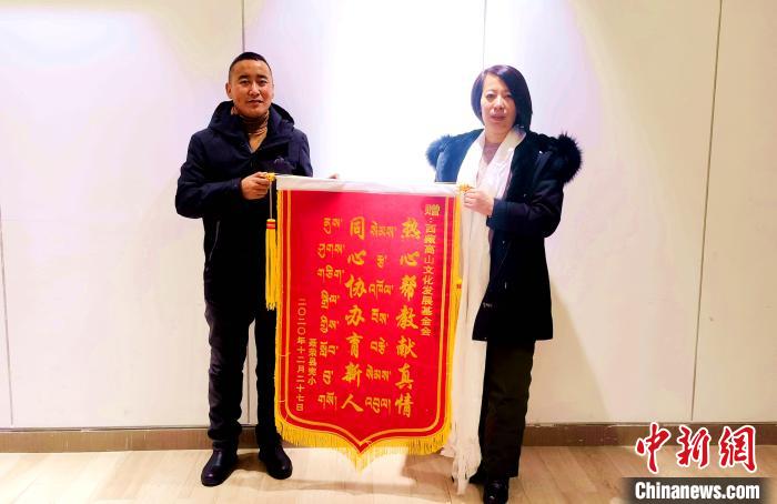 圖為(wei) 聶榮縣完全小學向西藏高山文化發展基金會(hui) 贈送錦旗。　於(yu) 賓 攝