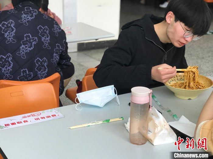 3月17日，西藏大學學生正在學校食堂用餐，餐桌上寫(xie) 著“按需取餐，切勿浪費”。　冉文娟 攝