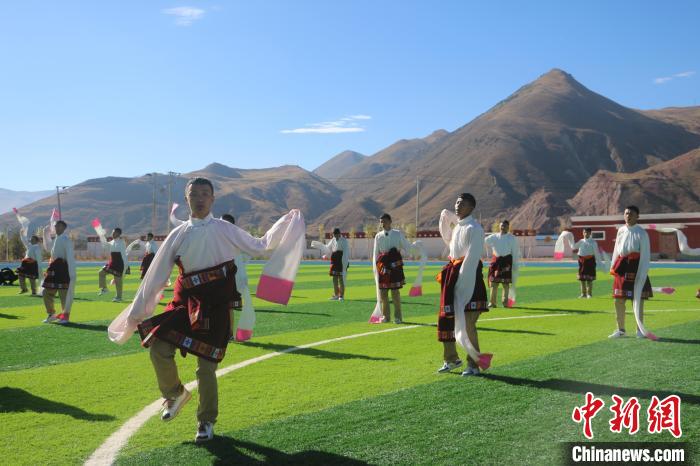 圖為青海師範大學附屬玉樹實驗學校學生在綠茵場跳起囊謙古舞—卓根瑪。　程雨 攝