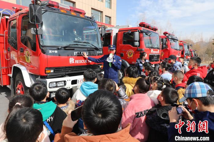 圖為(wei) 消防員向小朋友們(men) 講解消防車。　楊龍建 攝