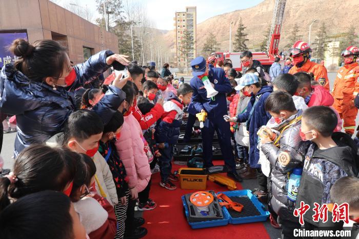 圖為(wei) 小朋友們(men) 聽消防員講解消防器材。　楊龍建 攝