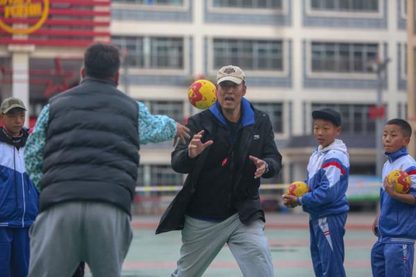 在高原上教孩子們(men) 打手球，“慢慢兒(er) 來，甭著急！”