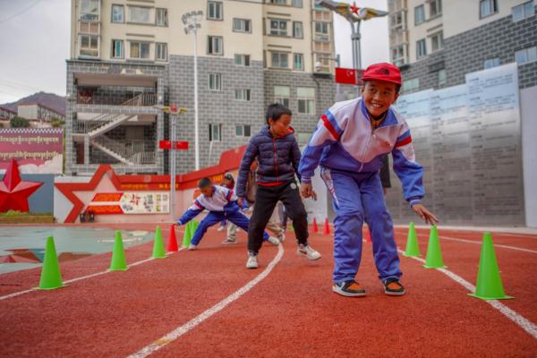 在高原上教孩子們(men) 打手球，“慢慢兒(er) 來，甭著急！”