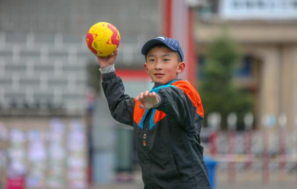 在高原上教孩子們(men) 打手球，“慢慢兒(er) 來，甭著急！”