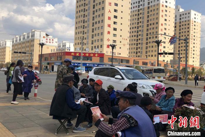 圖為(wei) 會(hui) 澤縣城易地扶貧搬遷安置點內(nei) ，老人們(men) 聚在廣場上聊天，身後是他們(men) 的新家。　繆超 攝