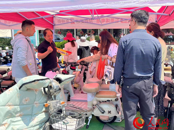 某電動自行車品牌工作人員向消費者介紹以舊換新相關(guan) 情況。人民網記者 杜燕飛攝