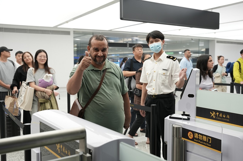 杭州海關(guan) 所屬杭州蕭山機場海關(guan) 關(guan) 員引導國外旅客通過一體(ti) 化智能閘機進行通關(guan) 。周雨亮攝