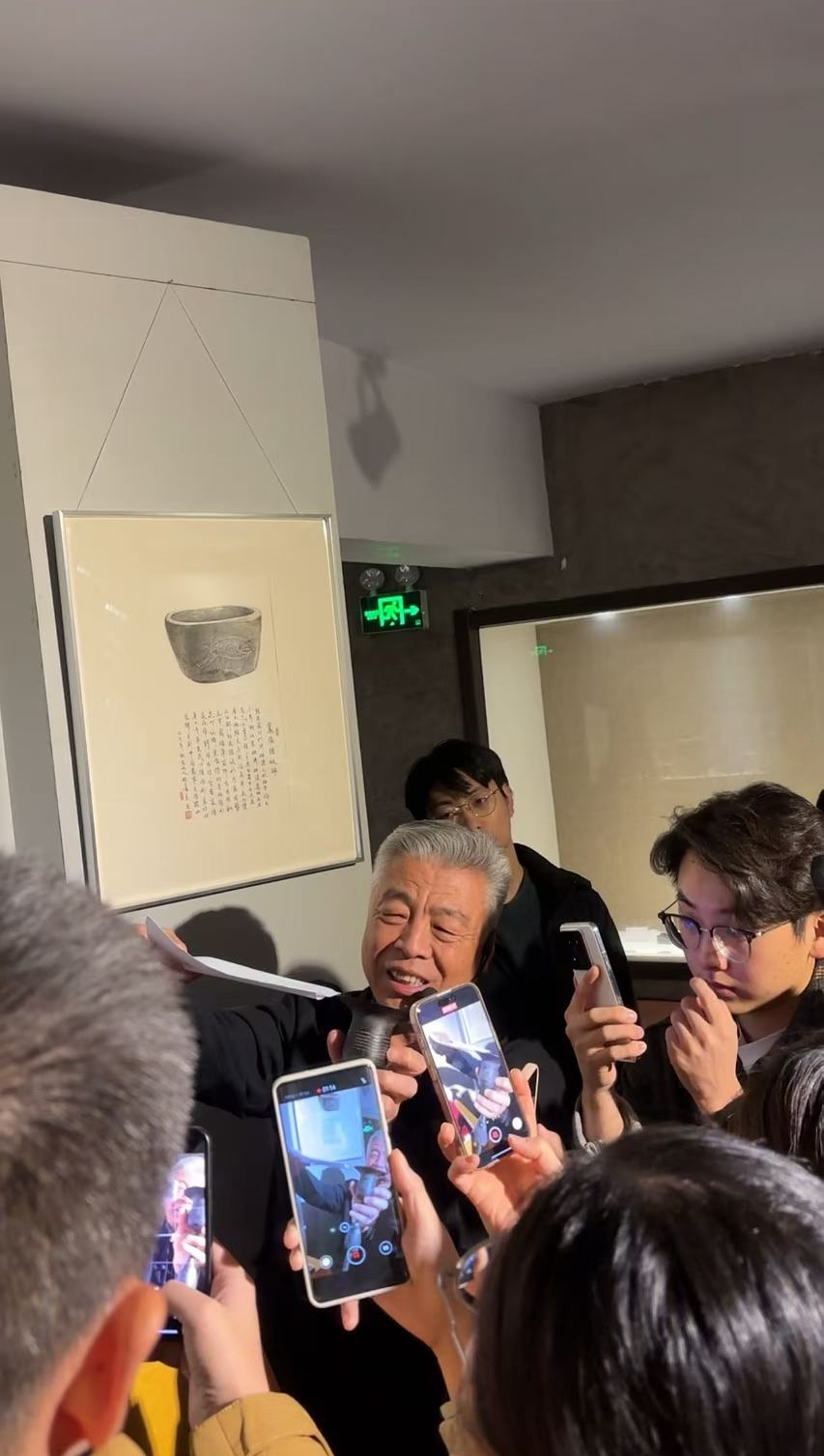 黑陶邢文化博物館館長邢葆東(dong) 展示兩(liang) 張相疊的A4紙，向記者解釋此為(wei) 杯口的厚度。