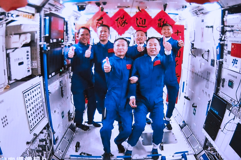 2023年5月30日，在北京航天飛行控製中心拍攝的神舟十五號航天員乘組與(yu) 神舟十六號航天員乘組拍下“全家福”的畫麵。
