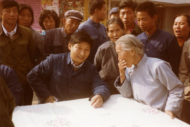 1983年，時任河北正定縣委書(shu) 記的習(xi) 近平（前排居中），臨(lin) 時在大街上擺桌子聽取老百姓意見。