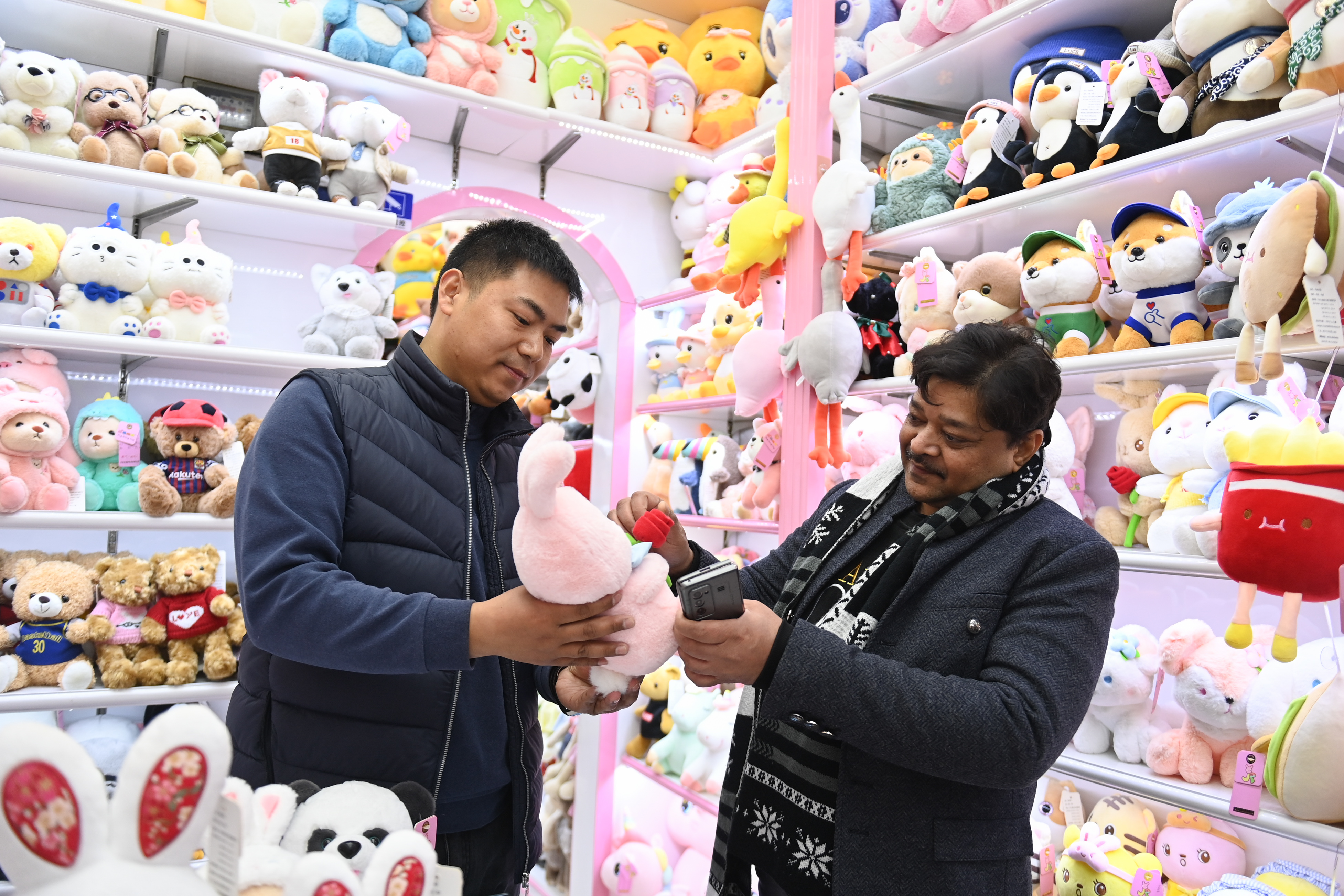 2023年2月2日，來自印度的客商（右）在義(yi) 烏(wu) 國際商貿城的一家玩具店鋪內(nei) 選購。