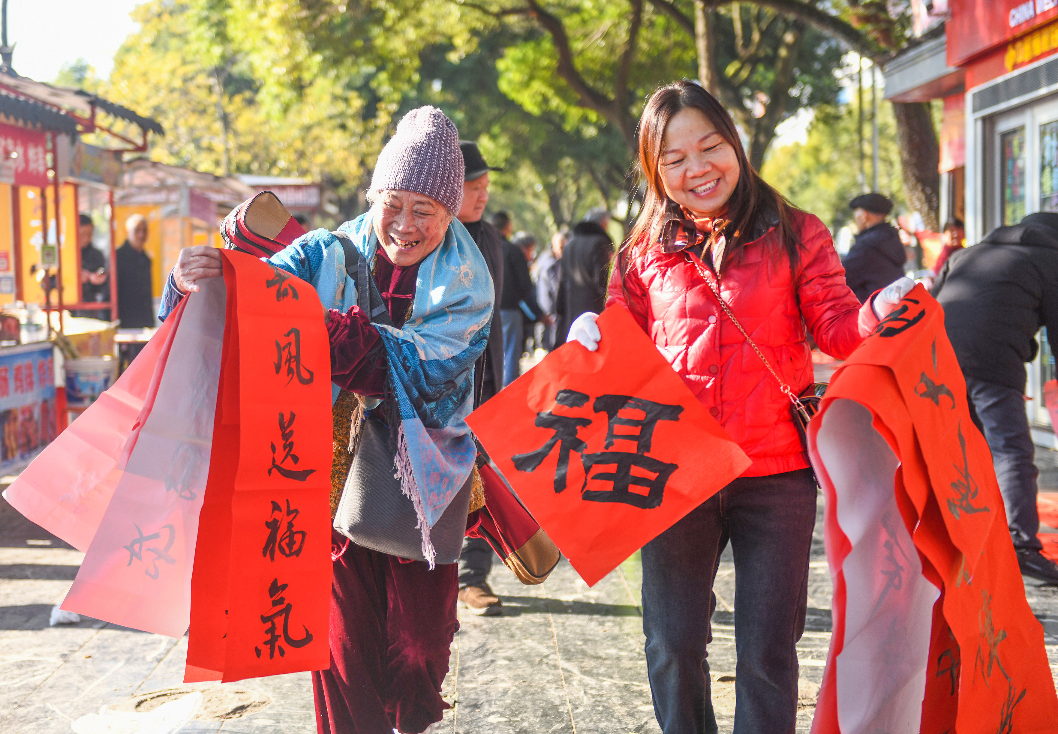 2025年1月13日，在湖南省永州市道縣西洲公園義(yi) 工崗亭，市民們(men) 領到了書(shu) 法誌願者為(wei) 大家書(shu) 寫(xie) 的春聯。