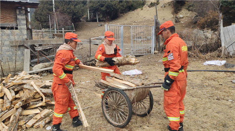 圖為李慶正帶著指戰員們幫助駐地居民整理木柴.jpg