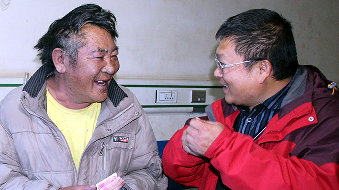 6、這是中國石化援藏幹部王鵬雁（右）來到�?�結對子”幫扶對象的紮紮（左）家中，為他妻子英秋治病送去自掏腰包的�?��?�需的治療費（紮�?2014�?7�?9日攝）_副本.jpg