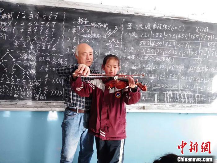 圖為(wei) 趙興(xing) 洲教學生拉小提琴。受訪者提供