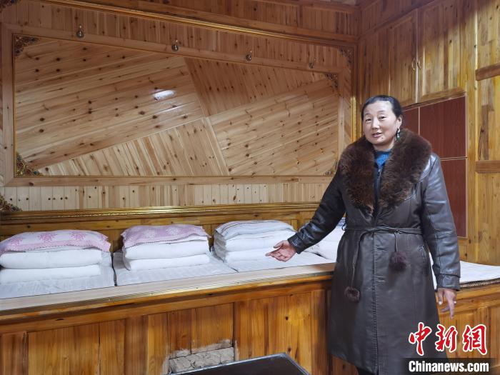 圖為(wei) 德吉村村民鬧尖措介紹自家農(nong) 家樂(le) 。　祁增蓓 攝