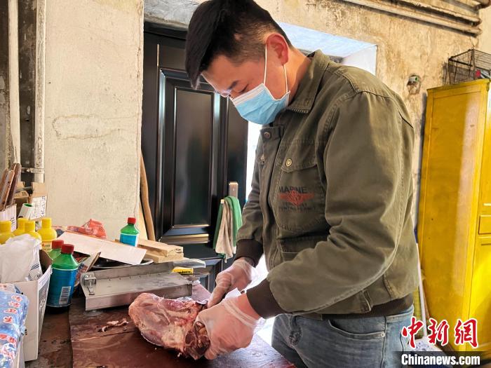 圖為(wei) 雪豹“奶爸”史壽軍(jun) 正在準備投喂雪豹的食材。　馬銘言 攝